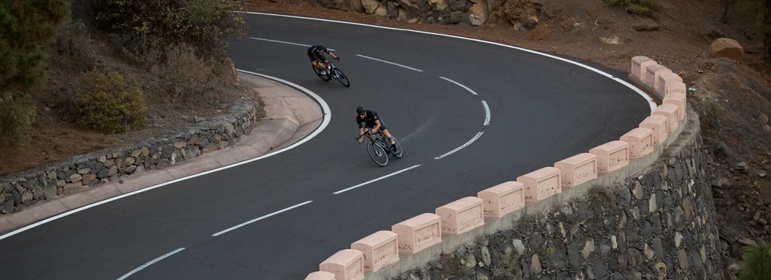Two cyclists on a road with a Magma bike.